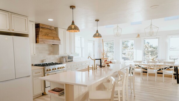 A modern kitchen with white cabinetry, a large island, and pendant lighting.