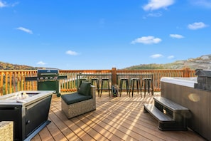 Eine Terrasse mit Grill, Whirlpool und Gartenmöbeln.