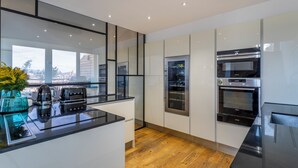 Una cucina moderna con una grande isola, forni integrati e vista sulla città.