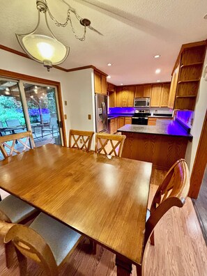 Eine moderne Küche mit Holzschränken, einem Edelstahlkühlschrank und einer Mikrowelle.
