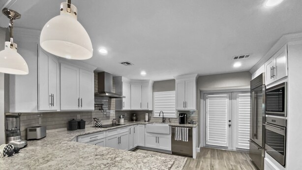 A modern kitchen with white cabinets, a marble countertop, and stainless steel appliances. - Modern Luxury Private Home with Pool in Siesta Key (Siesta Key)