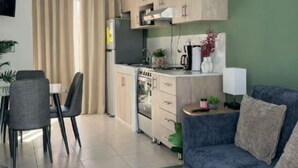 A compact living space with a kitchenette, a dining area, and a sofa.