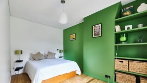 A bedroom with a bed, a green wall, a white ceiling, and a wooden floor. - Bastille · 11th · Stylish & Quiet Studio – managed by Mey Agency (Paris)
