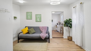 A living room with a sofa, a rug, and a potted plant. - Stroll to the Dome Sleek 1BR Near Downtown (San Antonio)