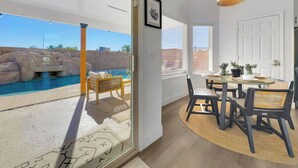 Un interno moderno con zona pranzo, vista piscina e porta che dà sull'esterno.