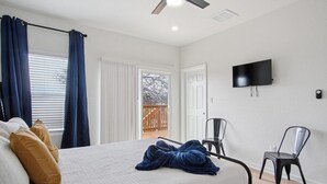 A bedroom with a bed, a television, and a balcony door. - Minutes to Downtown Spacious 4BR 3BA Historic Gem (San Antonio)