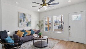 A modern living room with a sofa, armchair, and round coffee table. - Minutes to Downtown Spacious 4BR 3BA Historic Gem (San Antonio)
