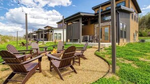 A modern house with a patio area featuring outdoor seating and a fire pit. - Peaceful cabin retreat near all you want to do in the Smokey Mountains! (Sevierville)