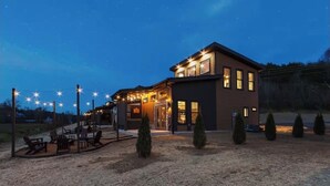 A two-story house with a patio area and string lights. - Peaceful cabin retreat near all you want to do in the Smokey Mountains! (Sevierville)