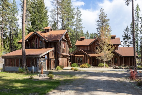 Un lodge rústico con varias cabañas de madera, rodeado de altos pinos.