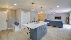 A spacious living area with a large island, a sofa, and a TV. - Charming 4-bedroom 2.5 Bath one level house with garage 7 miles from NRG stadium (Houston)