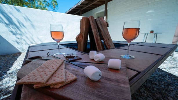 A wooden table with snacks, glasses of drink, and marshmallows. - Cozy 2BR W/ Desk • Fast Wi-Fi • Easy Parking (Tucson)