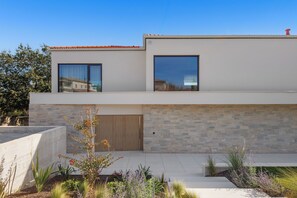 A modern two-story house with a large window, a wooden door, and a stone wall. - Villa Lavis (Istria - Sveti Lovreč) (Sveti Lovreč)