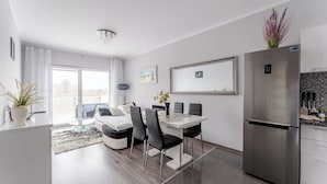 Eine moderne Küche mit Essbereich, Edelstahlkühlschrank und großem Fenster.