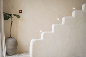 A staircase with a textured wall and a potted plant. - House Of Lucky Seseh (Cemagi)