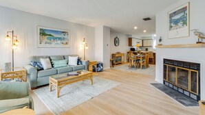 A living room with a sofa, coffee table, and fireplace.