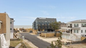 A multi-story building with a sign reading 'ATLANTIC VIEW,' a parking area, and a beach in the background.