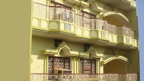 Un edificio de varios pisos con balcones, barandillas decorativas y elementos arquitectónicos tradicionales.