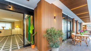 A modern hotel lobby with a checkered floor, wooden panel walls, and a seating area with wicker chairs and tables. - 1 bedroom awesome apartment in Alghero (Alghero)