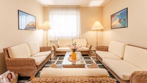 A cozy living room with wicker furniture, a central coffee table, and two lamps. - 1 bedroom awesome apartment in Alghero (Alghero)