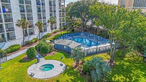 A residential complex with a swimming pool, a circular hot tub, and a small garden area. - Sea Mark Tower Unit 204 (Myrtle Beach)