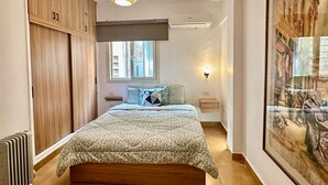 Ein Schlafzimmer mit einem großen Bett, einem Holzschrank und einem Gemälde an der Wand.