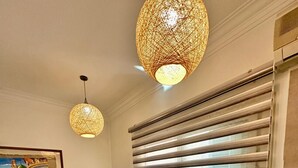 Eine kompakte Küche mit Kühlschrank, Wasserspender, Mikrowelle, Herd und einem großen Fenster mit Jalousien.