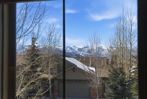 Ein Wohngebiet mit einem Haus im Vordergrund und schneebedeckten Bergen im Hintergrund.