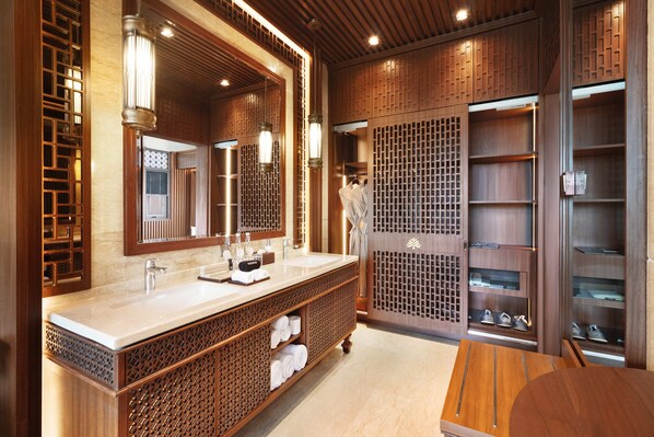 A modern bathroom with a large mirror, a sink, and a wooden vanity. - MĀUA OLEA Ubud by Swiss-Belhotel (Ubud)