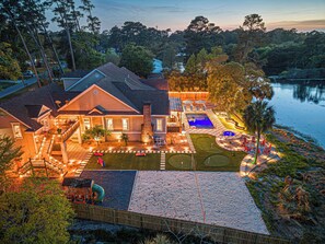 A house with a swimming pool, a tennis court, and a fenced yard.