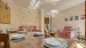 A dining area with a marble table, pink chairs, and a ceiling light fixture. - C Marinaio-vista mare e centro (Recco)