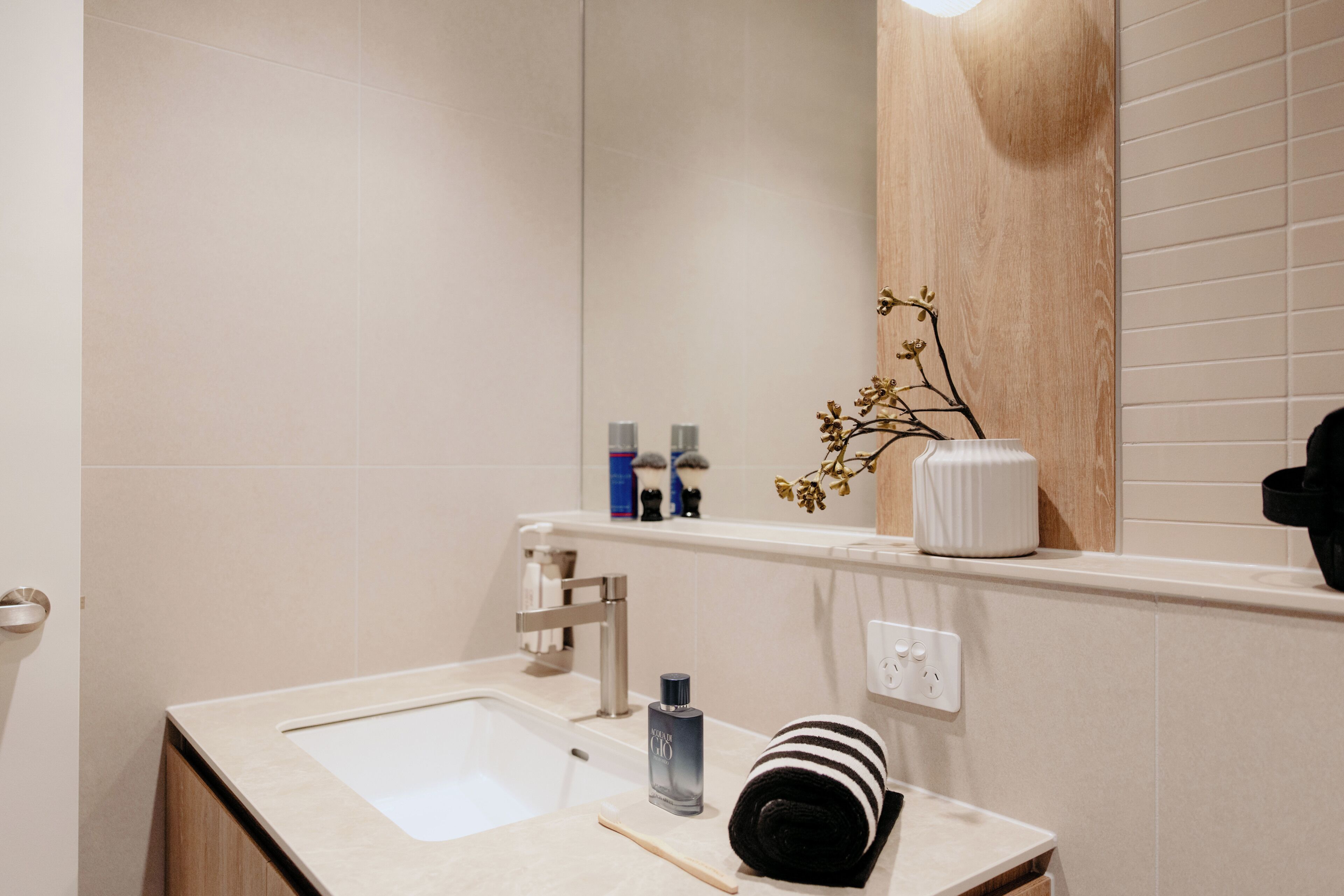 A bathroom with a sink, mirror, and toiletries.