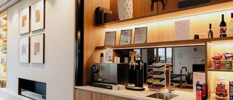 Moderni kahvila, jossa on espressokoneita, pesuallas ja erilaisia kahviin liittyviä tarvikkeita.