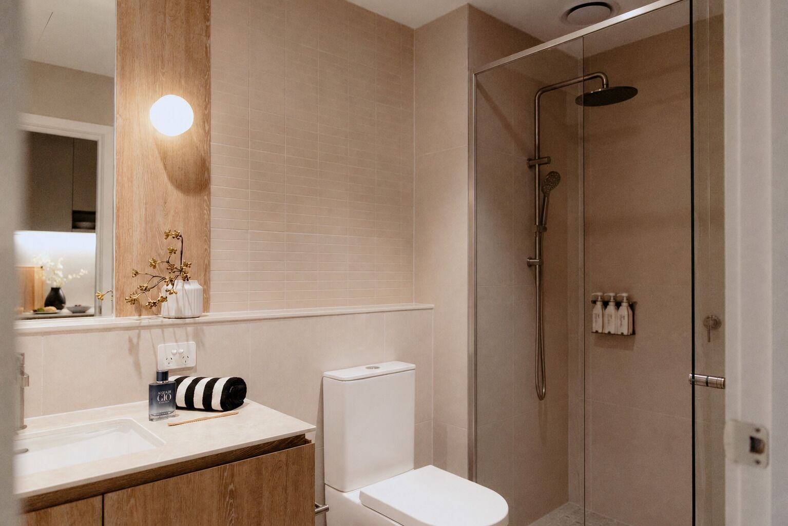 A modern bathroom with a toilet, sink, and shower.