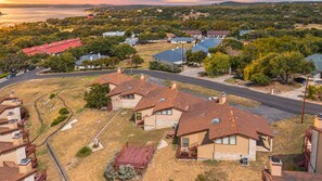 A residential area with houses, a road, and a body of water in the background. - Dog-friendly condo with a gas fireplace, washer/dryer, AC, & cable TV (Canyon Lake)