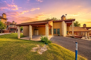 A two-story building with a covered patio, stone pillars, and a garage. - Dog-friendly condo with a gas fireplace, washer/dryer, AC, & cable TV (Canyon Lake)