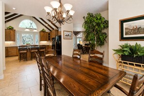A spacious kitchen with wooden cabinets, a large dining table, and a chandelier. - 5-acre Hill Country home with views & outdoor entertaining - dog-friendly (Canyon Lake)