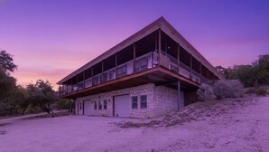 Ein zweistöckiges Steinhaus mit Balkon und Garage.
