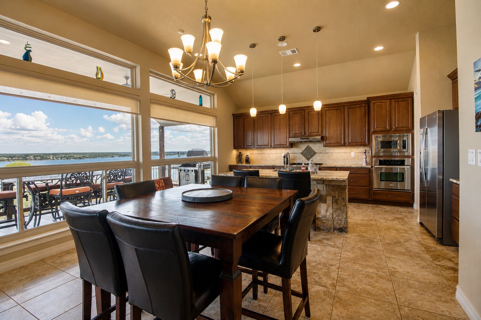 A spacious kitchen with a large dining table, modern appliances, and a view of the outdoors.