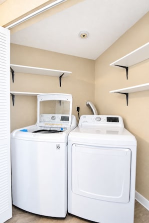 A laundry room with two stacked front-loading washing machines and a vent. - Lovely home on 2+ acres with views, firepit & outdoor kitchen - wedding perfect (Dripping Springs)