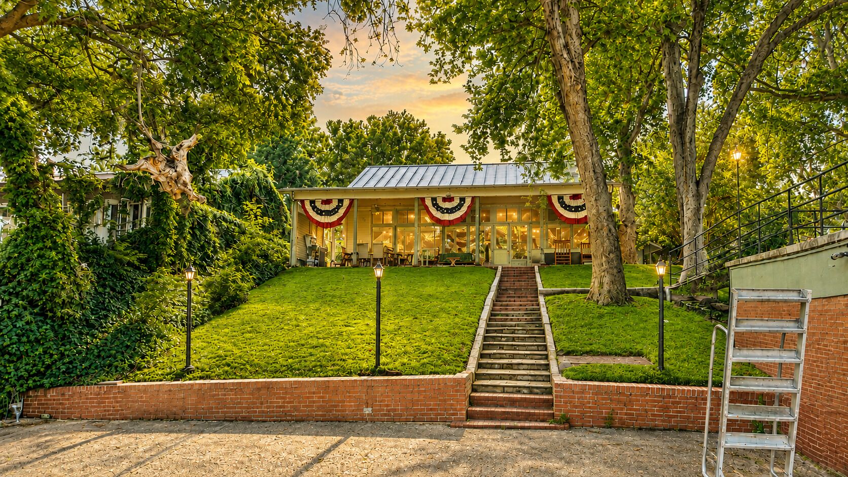 A building with a front entrance, a set of stairs leading up to it, and a surrounding grassy area.