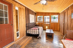 A wooden interior with a bed, a table, and a chair. - Charming dog-friendly home with expansive deck - near boat ramp & attractions (New Braunfels)
