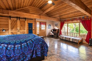 Una habitación de madera con una cama, un escritorio y un banco.