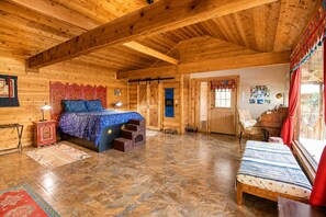 A wooden cabin interior with a bed, a piano, and a bench. - Charming dog-friendly home with expansive deck - near boat ramp & attractions (New Braunfels)