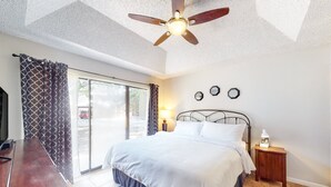A bedroom with a bed, a ceiling fan, a nightstand, and a window with curtains. - 2BR Condo W/ Pool, Hot Tub, Grills, Walk to Schlitterbahn! (New Braunfels)