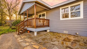 Ein Haus mit einer Steinterrasse, einer Holzveranda und Blick zum Himmel.
