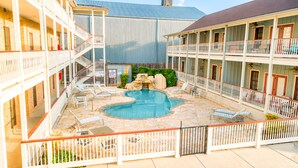 Ein Hotel mit Swimmingpool, Außenbereich und einem eingezäunten Innenhof.