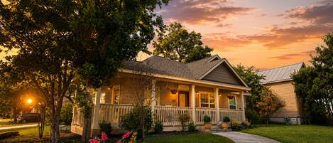 A two-story house with a front porch, a driveway, and a well-maintained lawn.