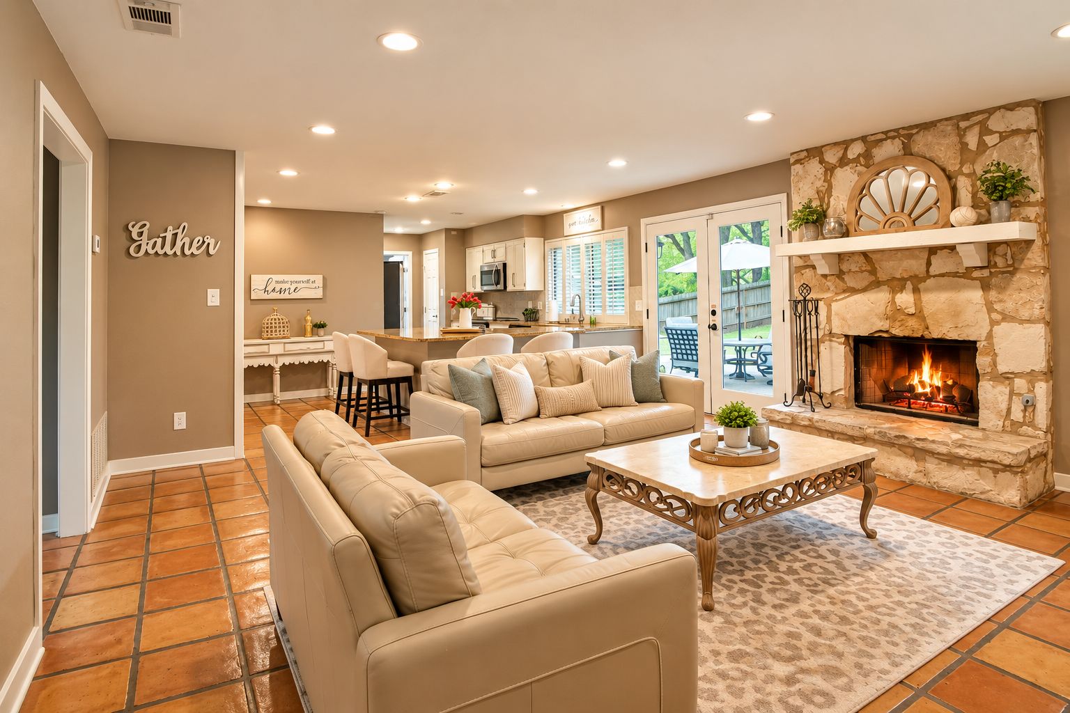 A spacious living room with a fireplace, a kitchen in the background, and a dining area.