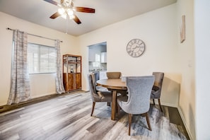 A dining area with a round table and four chairs, a ceiling fan, and a clock on the wall. - Roomy, modern farmhouse escape in the heart of downtown with central AC & heat (San Antonio)